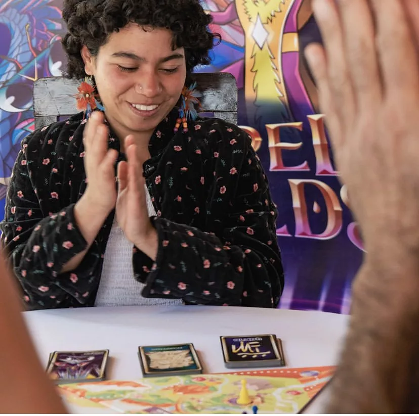 Young woman laughing joyfully during Sacred Worlds gameplay