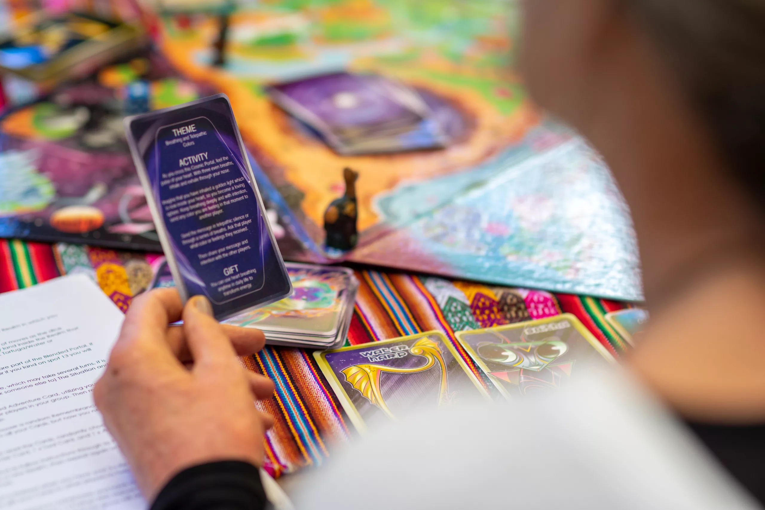 Player reading adventure card with colorful game board in background