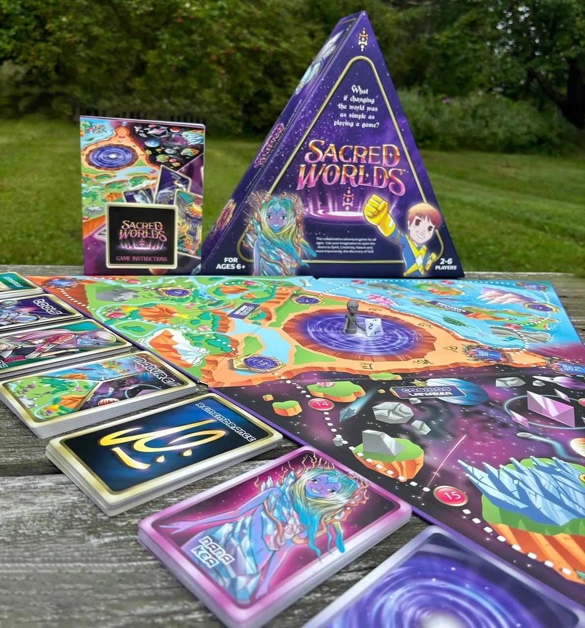 Sacred Worlds board game, box, cards, and board set up outdoors on a table